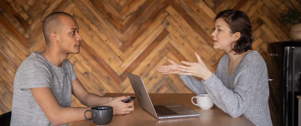 Two employees sat at a table having a conversation